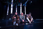 Drei Männer sitzen vor Birkenstämmen.