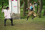 Zwei Leute kämpfen spielerisch mit Degen in einem Park