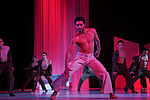 Othello und das Ensemble tanzen in rotes Licht getaucht
