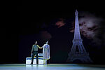 Othello und Desdemona stehen vor einem Bett, im Hintergrund der Eiffelturm