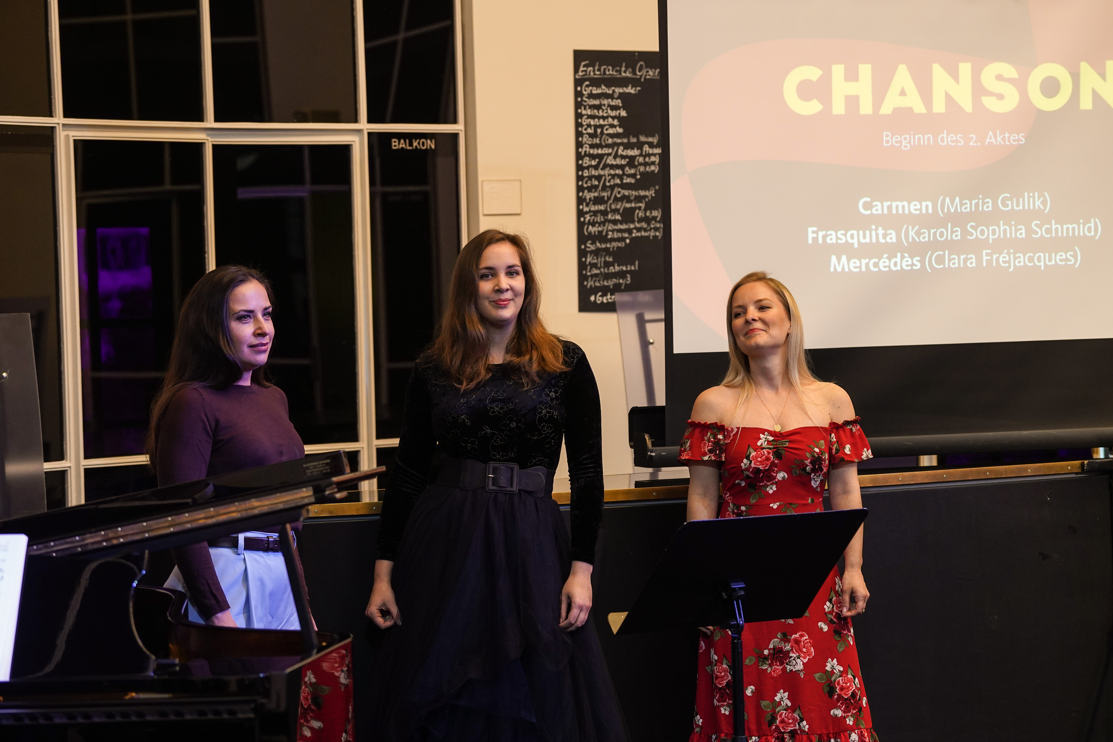 Die drei Sängerinnen Maria Gulik, Clara Fréjacques und Karola Sophia Schmid neben dem Flügel