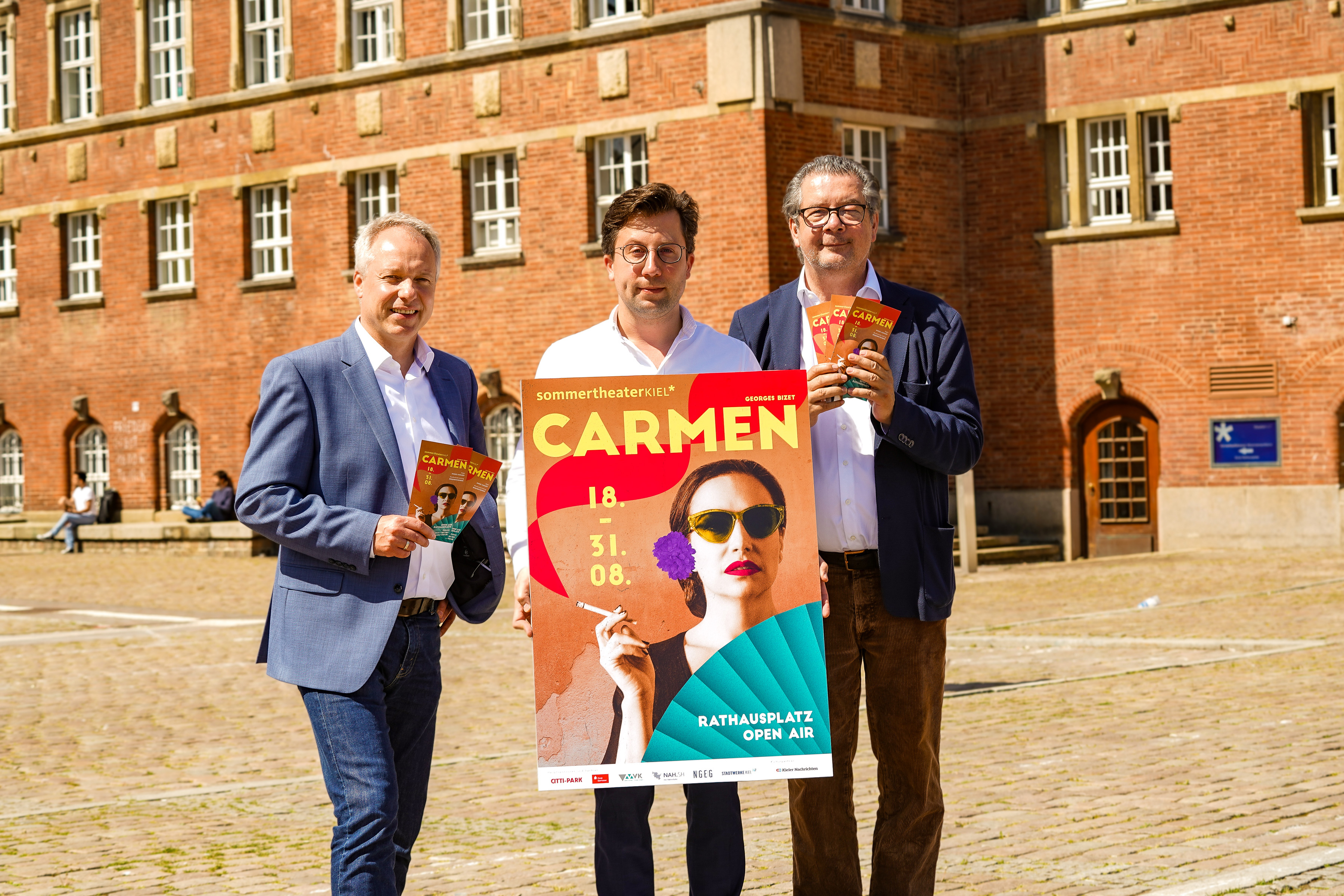 Roland Schneider, Benjamin Reiners und Daniel Karasek mit dem Carmen-Plakat auf dem Rathausplatz